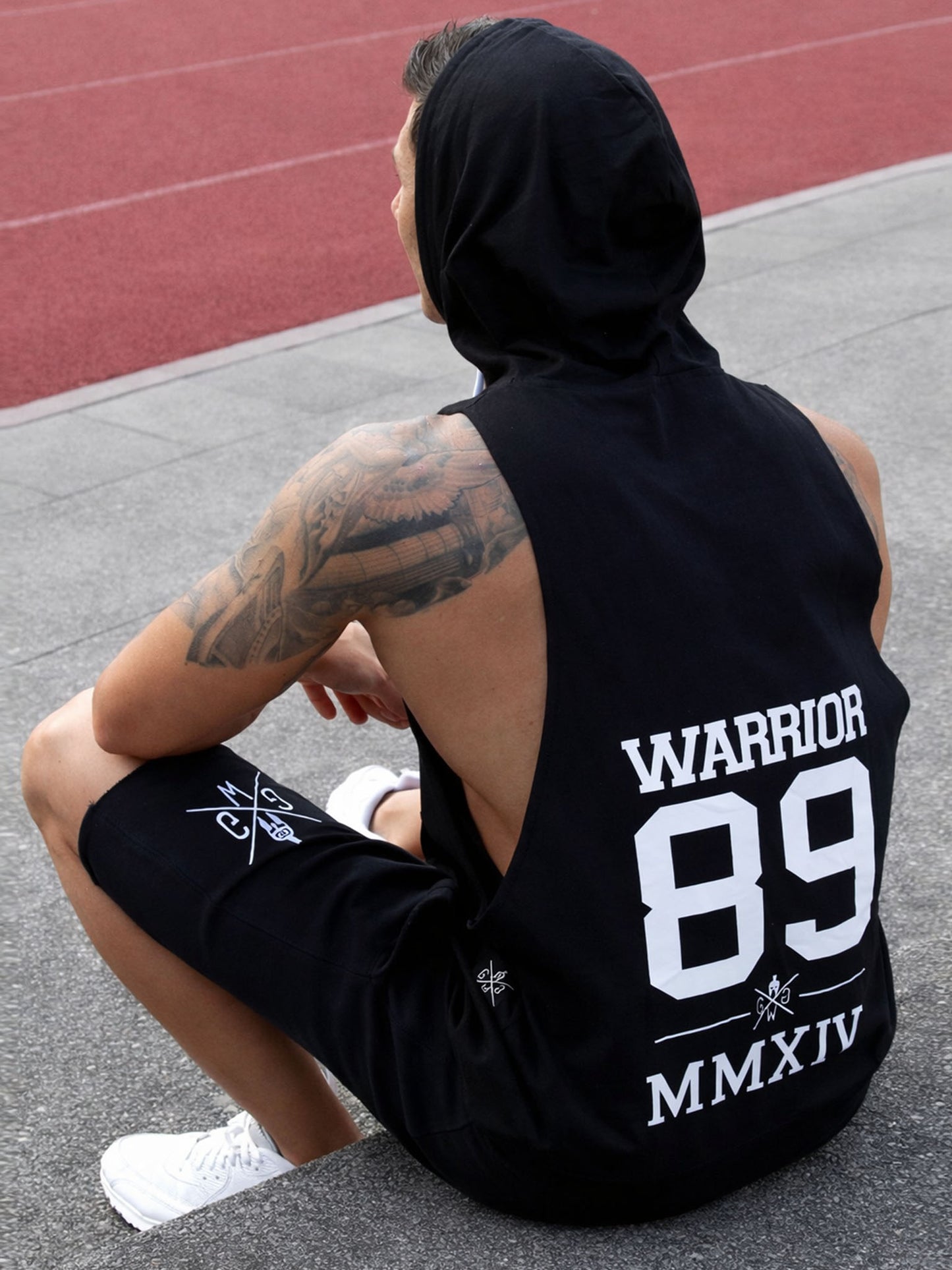 Schwarzes Kapuzen Tank Top für Herren von Gym Generation in Outdoor-Rückansicht – ärmelloser Fitness Hoodie mit großem Warrior 89 Backprint beim Workout