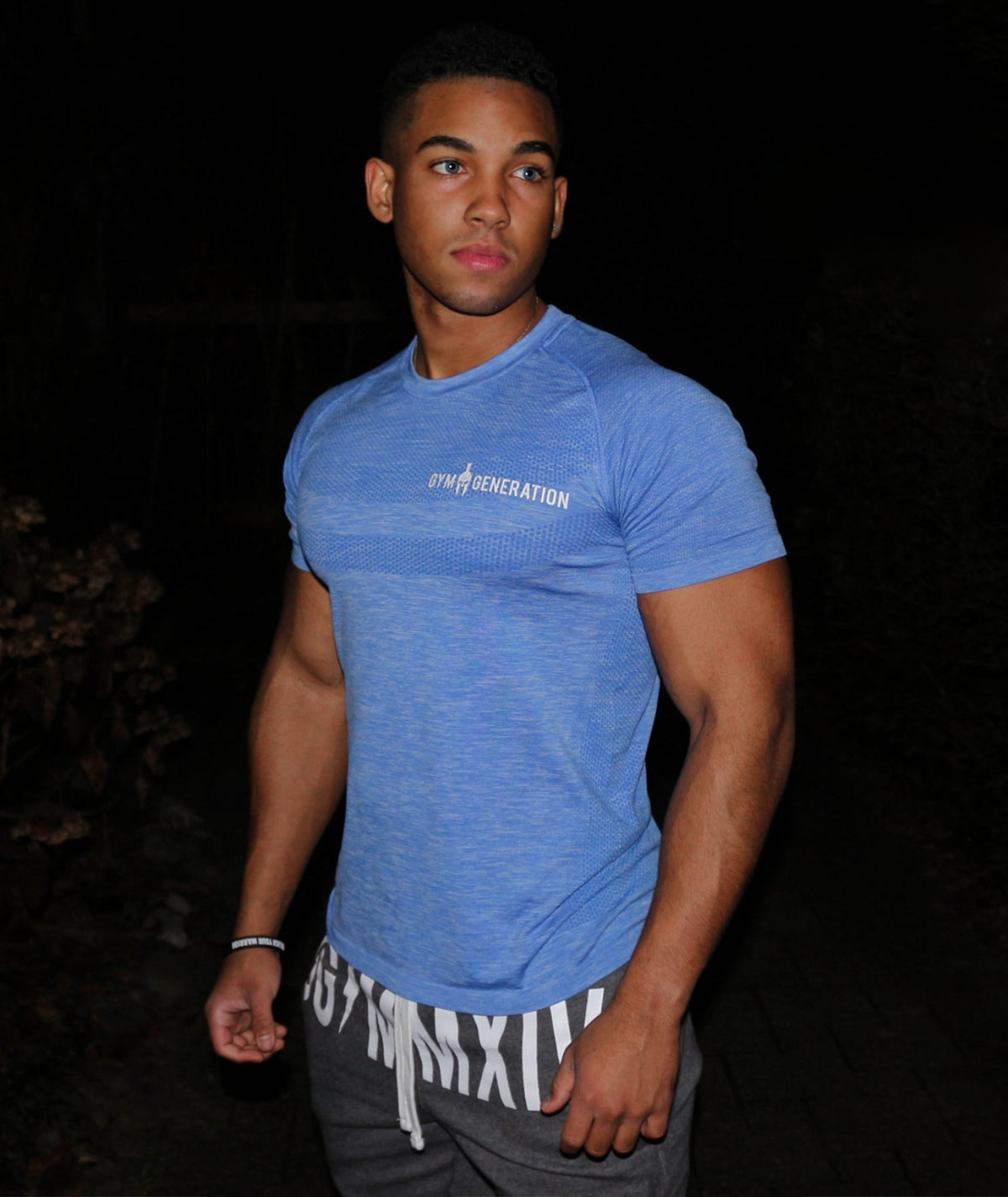 Men's seamless t-shirt in blue on a model, close-fitting with short raglan sleeves and white lettering, Gym Generation
