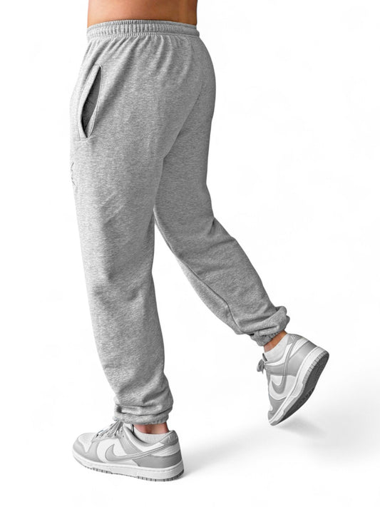 Graue Fitnesshose Herren mit elastischem Bund & dezentem Sticklogo. Die Rest Day Joggers sind atmungsaktiv, locker geschnitten & kombistark.