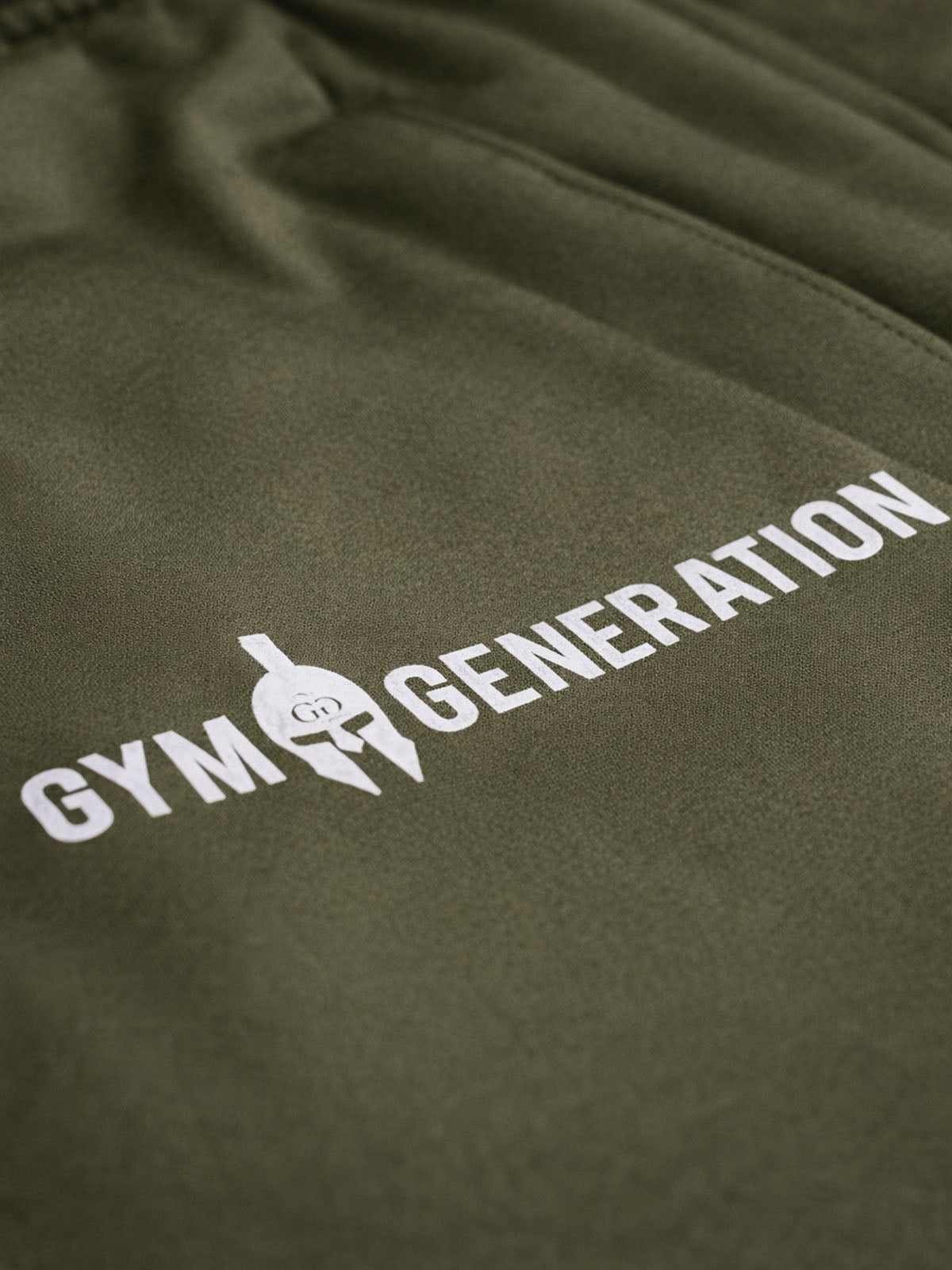 Detail Gym Generation Logo auf grüner Sporthose – hochwertige Herren Fitnesshose