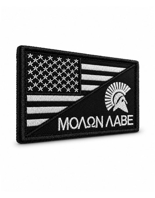 Molon Labe Patch von der Seite – dicht gestickte Oberfläche, sauber umnähte Kante und Klett-Hakenseite (Velcro) auf der Rückseite, weiss auf Schwarz.