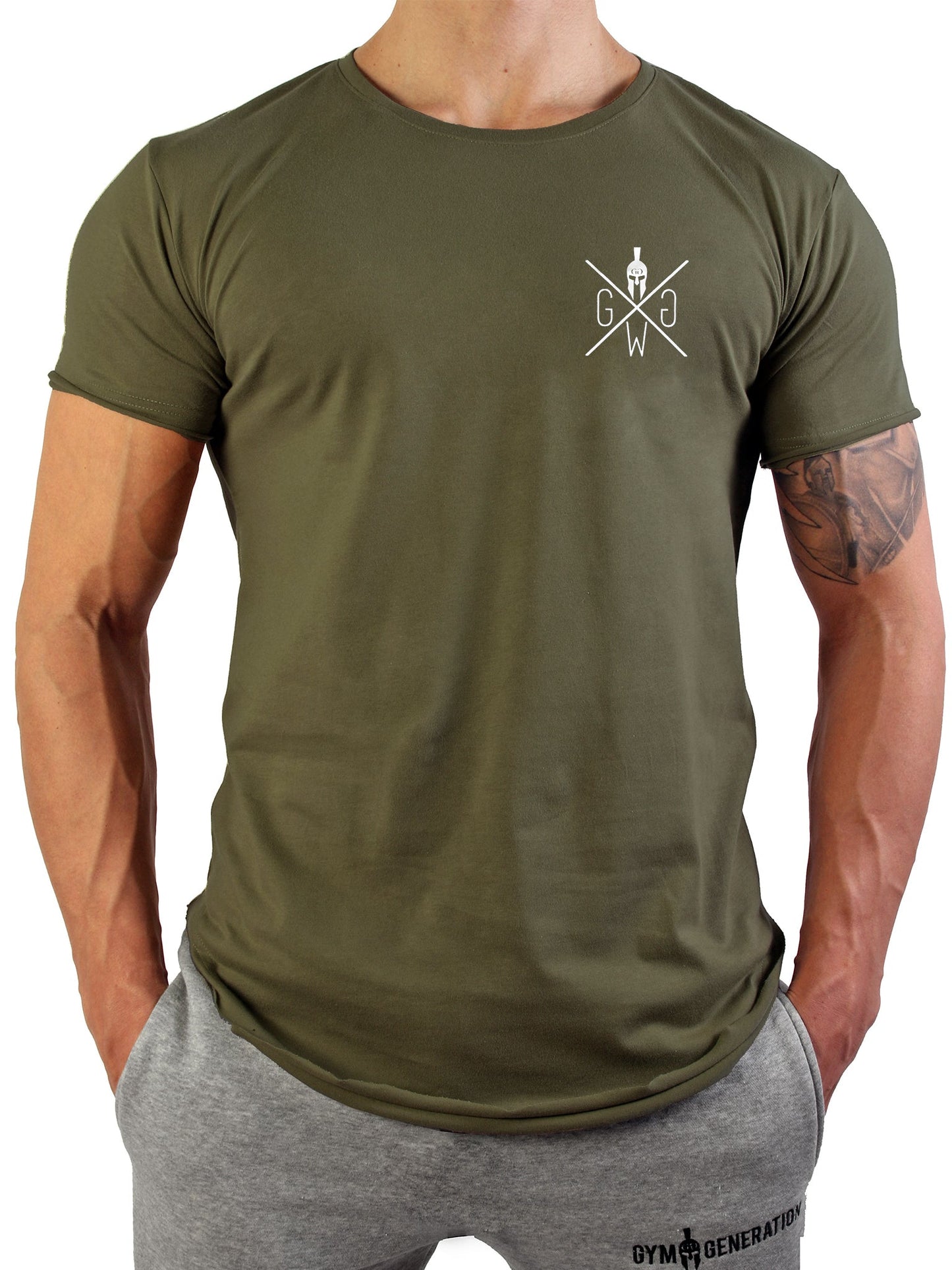 Frontansicht eines Mannes im Studio mit Gym Generation Valhalla T-Shirt in Olive, weissem Logo-Brustprint, kombiniert mit grauer Gym Generation Jogginghose.