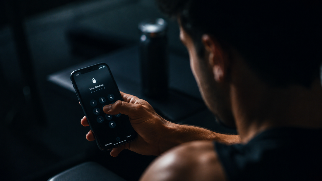 Mann hält gesperrtes Smartphone im Gym als Symbol für Dopamin Detox, Fokus, Disziplin und weniger Ablenkung