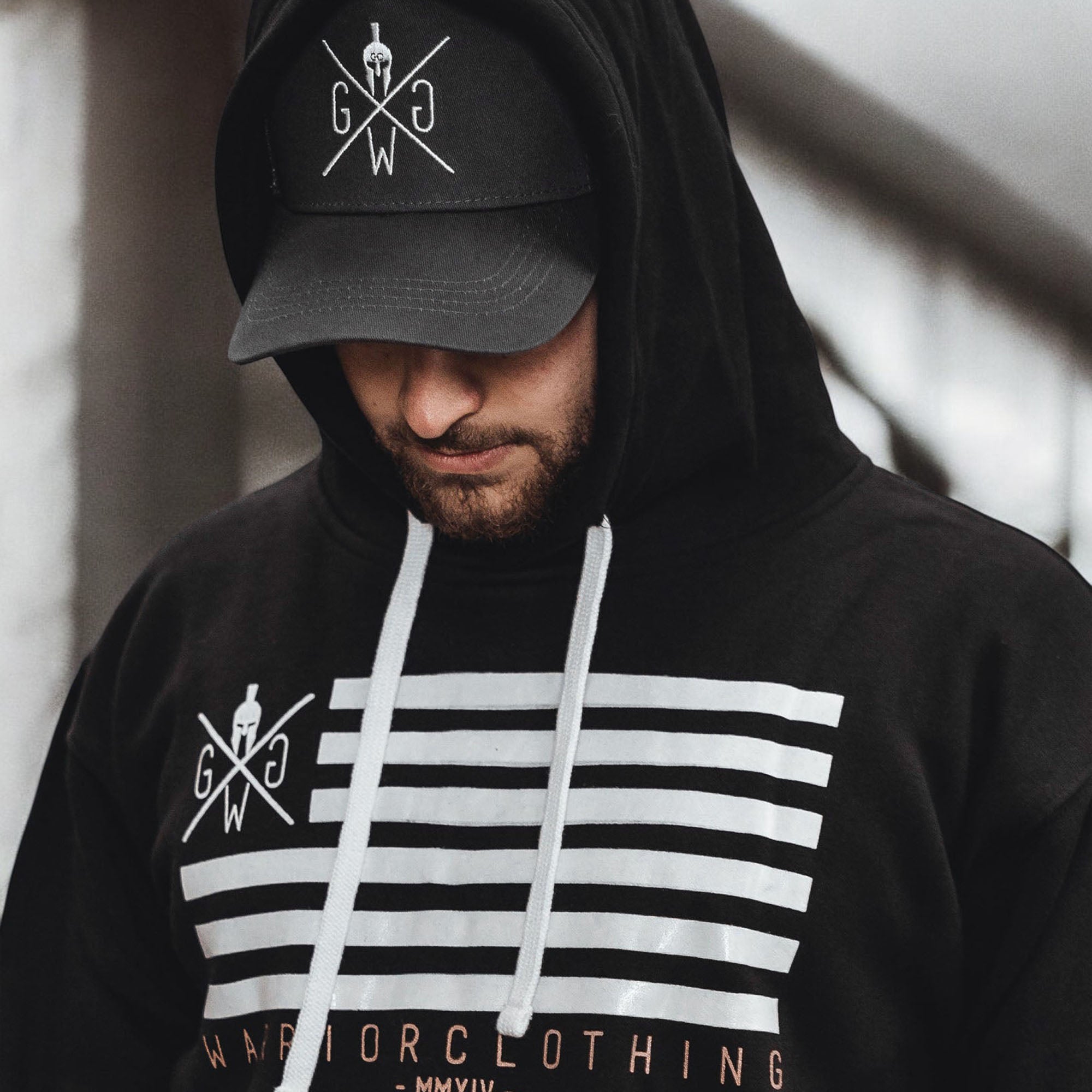Schwarze Gym Generation Cap mit gesticktem Logo, getragen unter schwarzem Hoodie im urbanen Gym-Look – sportliche Herren Cap für Training, Streetwear und Alltag.