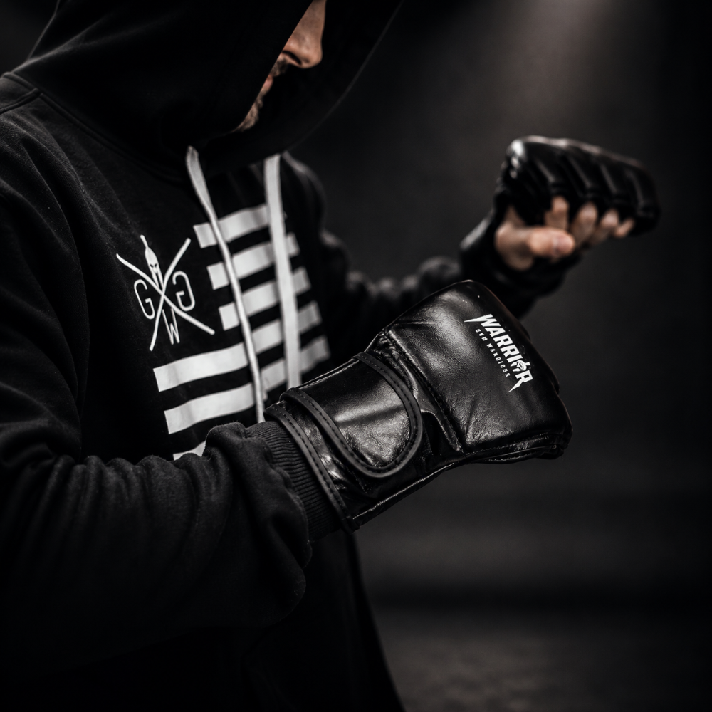 Athlet mit schwarzen Gym Generation Boxhandschuhen und Warrior Hoodie beim Kampfsporttraining, ideal für Boxen, Fitness und intensive Gym Workouts.