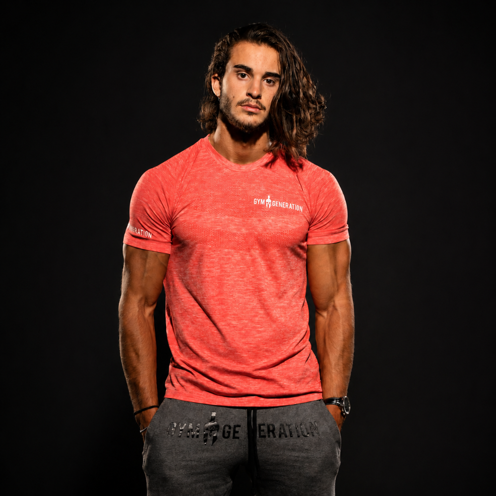 Athlet im roten Gym Generation T-Shirt und grauer Jogginghose im Fitnessstudio, ideal für Krafttraining, Bodybuilding und sportlichen Streetwear-Look.