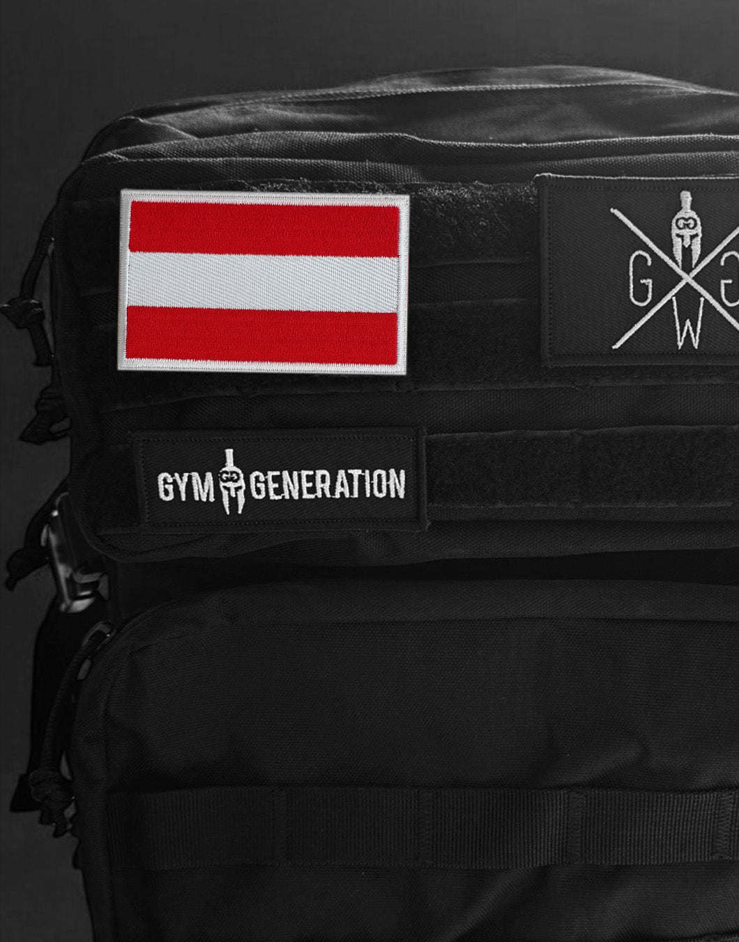 Österreich Flagge Patch Rot-Weiß-Rot mit Klettverschluss, befestigt auf schwarzem Tactical Backpack, robuster Stick für Outdoor-Gear, Supporter-Kultur, Sport-Fans und österreichische Diaspora in Europa.