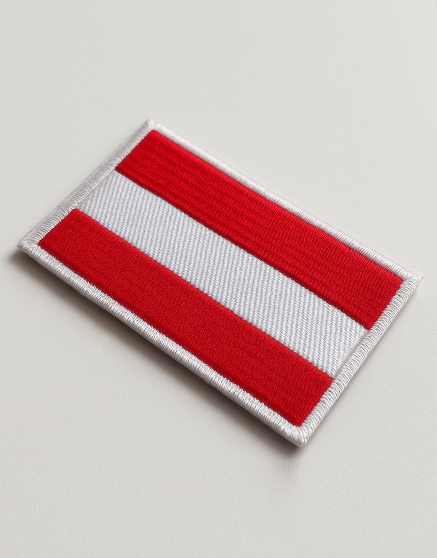 Austria Flag Patch Velcro Rot-Weiß-Rot, freigestelltes Produktbild mit detaillierter Stickqualität, ideal zur Personalisierung von Rucksäcken, Tactical Vests, Gym-Bags und Outdoor-Ausrüstung, wetterfest & langlebig.