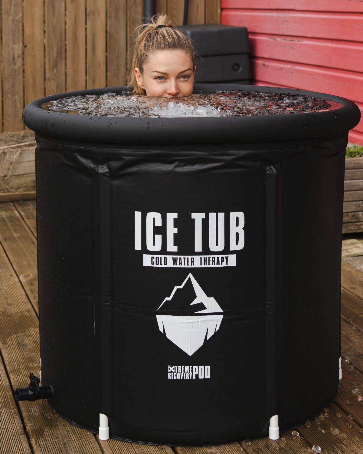 Schwarzes Ice Tub gefüllt mit kaltem Wasser und Eiswürfel - Frau nimmt ein Kälte Bad nach dem Training.