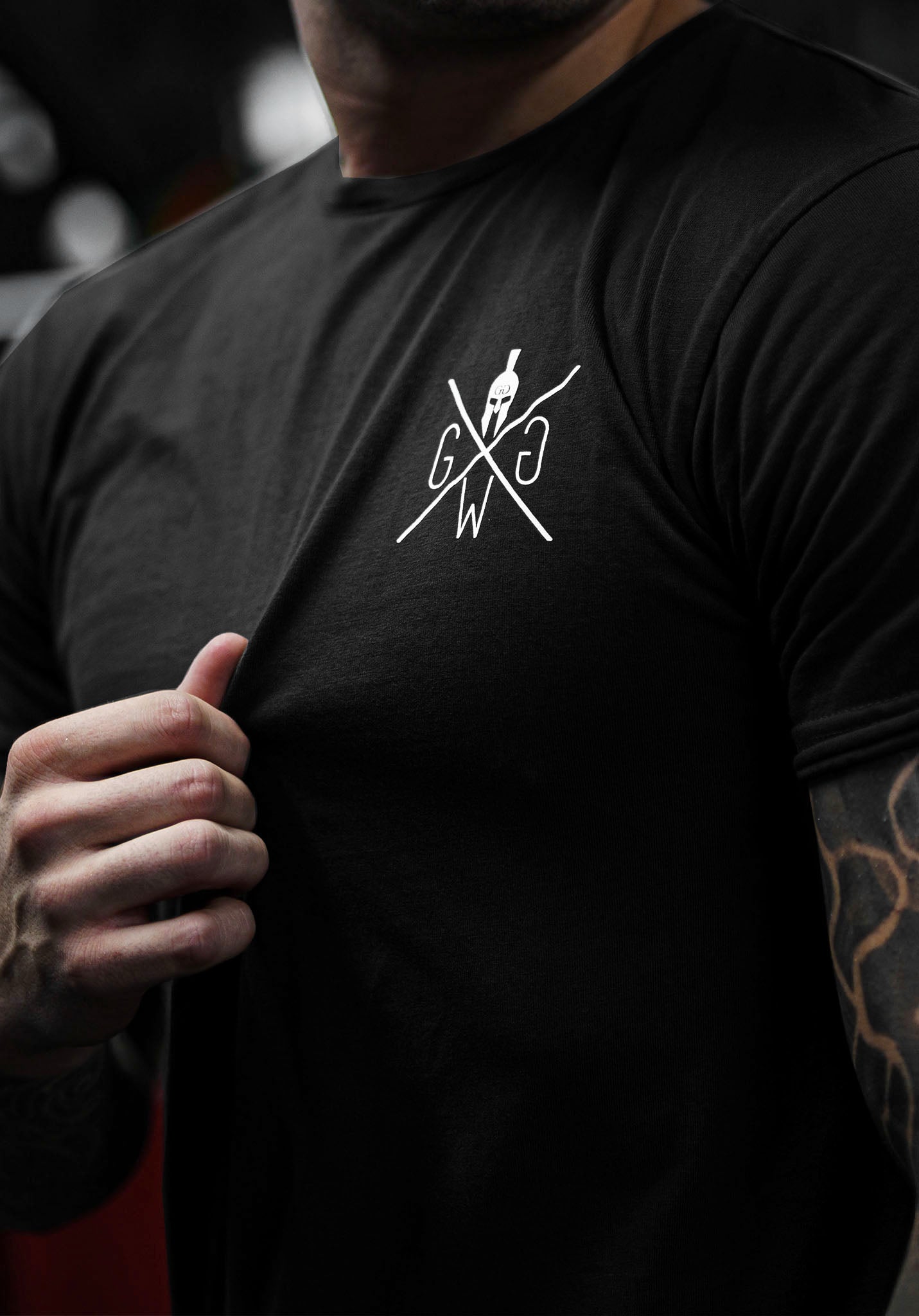 Gym Generation T-Shirt in Schwarz mit abgerundetem Saum und ikonischem Spartaner-Logo.