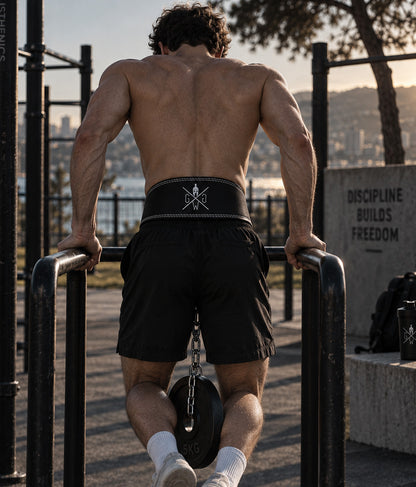 Athlet trainiert Weighted Dips am Barren mit dem Dip Gürtel aus Leder von Gym Generation, Hantelscheibe an der Stahlkette – Calisthenics im Outdoor-Park