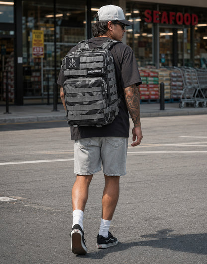 Gym Generation Fitness Rucksack in Grau Camo, getragen von Athlet vor Supermarkt im American Streetstyle mit Patches und MOLLE-System