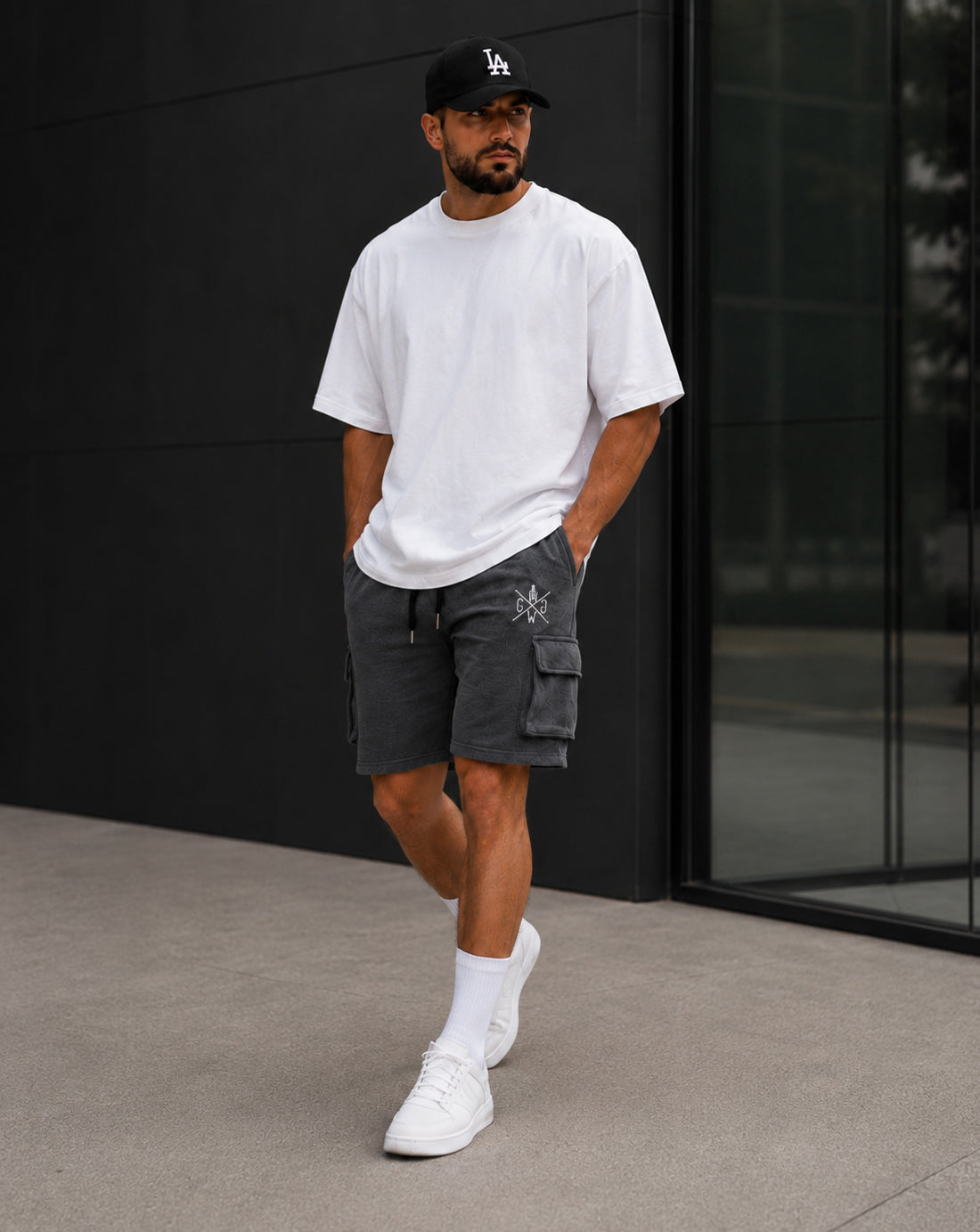 Athlet trägt Gym Generation Maverick Cargo Shorts Herren in Anthrazit im urbanen Streetstyle-Look