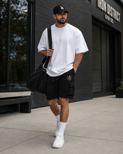 Gym Generation Maverick Cargo Gym Shorts Herren in Schwarz, getragen von Athlet Outdoor mit weissem Oversized Shirt, Cargo-Tasche und sportlichem Streetwear-Look