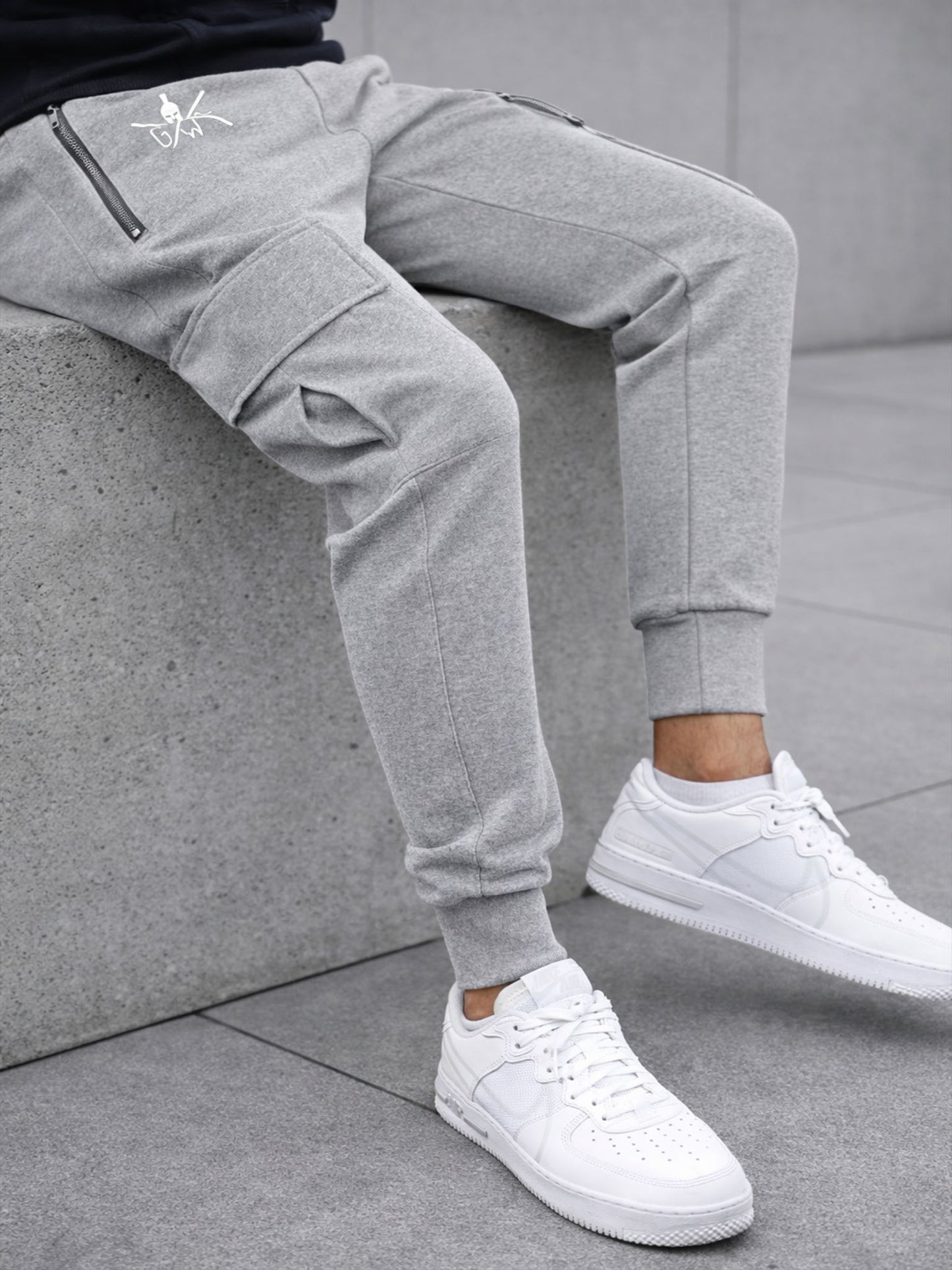 Graue Cargo Trainingshose für Herren von Gym Generation – seitliche Lifestyle-Aufnahme mit Cargo-Tasche, elastischem Bündchen und modernem Street-Look