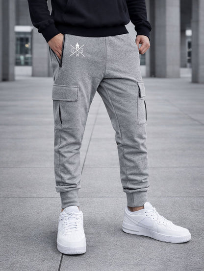 Graue Cargo Trainerhose für Herren von Gym Generation – urbanes Modellbild mit funktionalen Cargo-Taschen, Reissverschlussdetail und sportlichem Street-Style