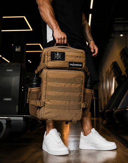 Gym Generation Fitness Rucksack Adventurer in Sahara Beige, getragen von Athlet im Gym mit MOLLE-System, Patches und robustem Backpack-Design
