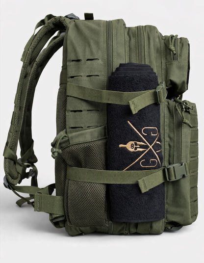 Olivgrüner Fitness-Rucksack von Gym Generation mit 45 L Volumen, schräge Seitenansicht mit befestigtem Handtuch und Netz-Flaschenhalter.