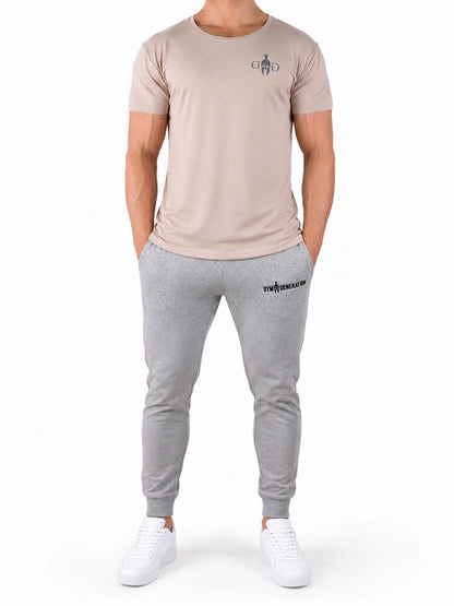 Fitness T-Shirt Herren Beige 'Club' von Gym Generation in Ganzkörperansicht – kombiniert mit grauem Jogger und weissen Sneakers, athletischer Fit für Gym und Streetwear