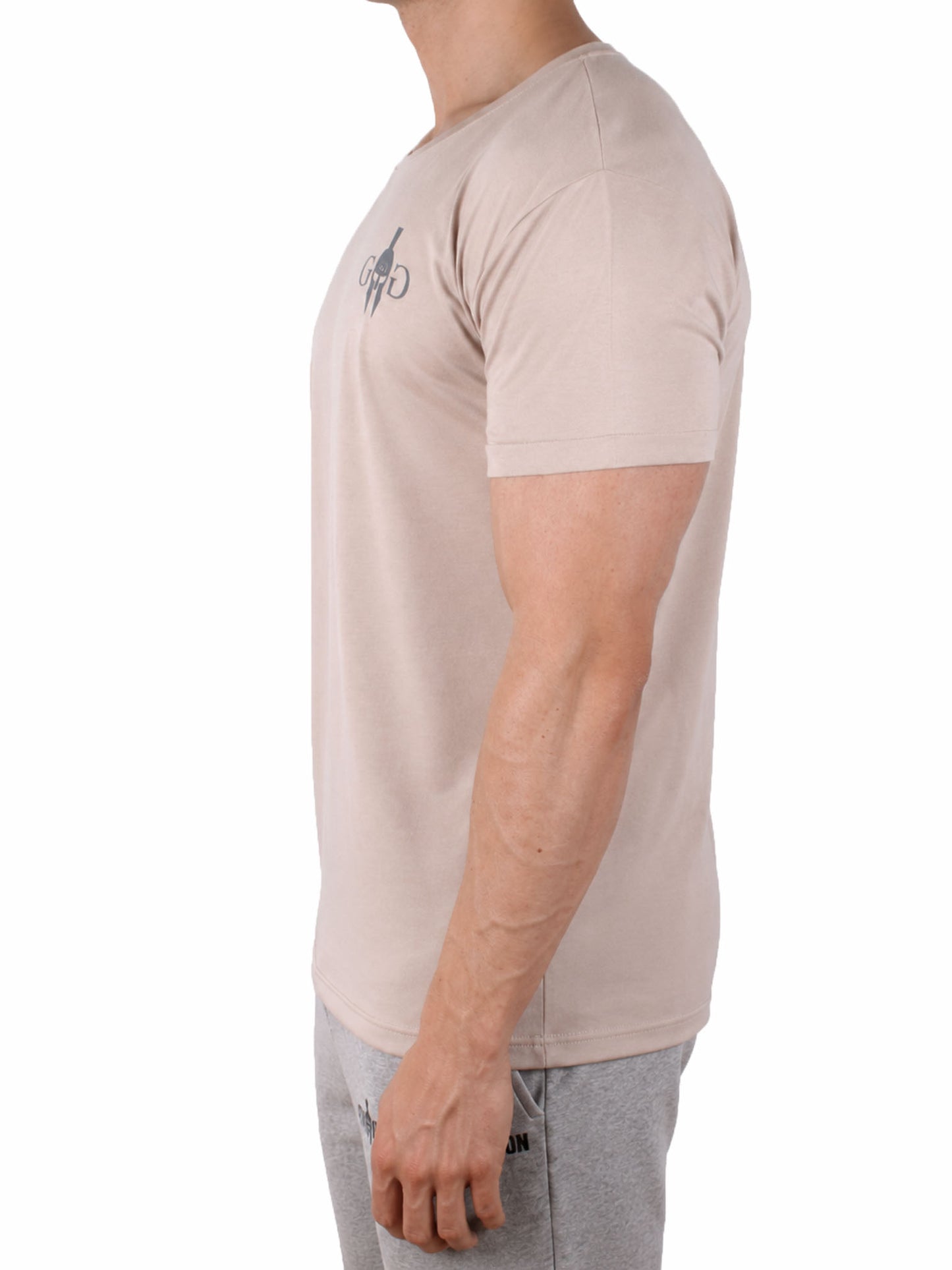 Fitness T-Shirt Herren Beige 'Club' von Gym Generation im Seitenprofil – körperbetonter Athletic Fit mit hochgekrempelten Ärmeln, getragen zu grauen Joggingpants