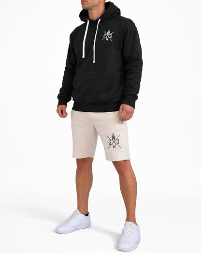Beige Gym Shorts Herren von Gym Generation im Outfit – sportliche Fitness Shorts am Model kombiniert mit schwarzem Hoodie und Sneakers