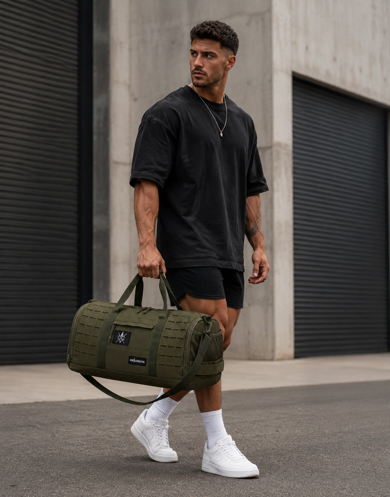 Gym Generation Fitness Sporttasche Maverick in Olive, getragen von Athlet Outdoor mit Tragegriffen, Laser-Cut-MOLLE und robustem Trainingsdesign