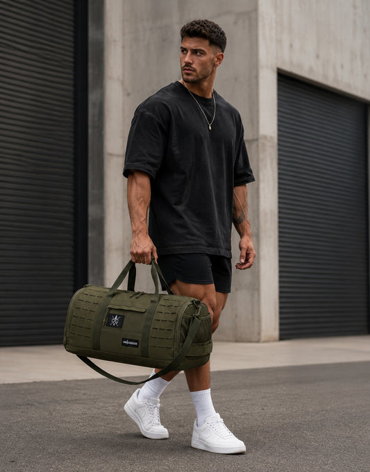 Gym Generation Fitness Sporttasche Maverick in Olive, getragen von Athlet Outdoor mit Tragegriffen, Laser-Cut-MOLLE und robustem Trainingsdesign