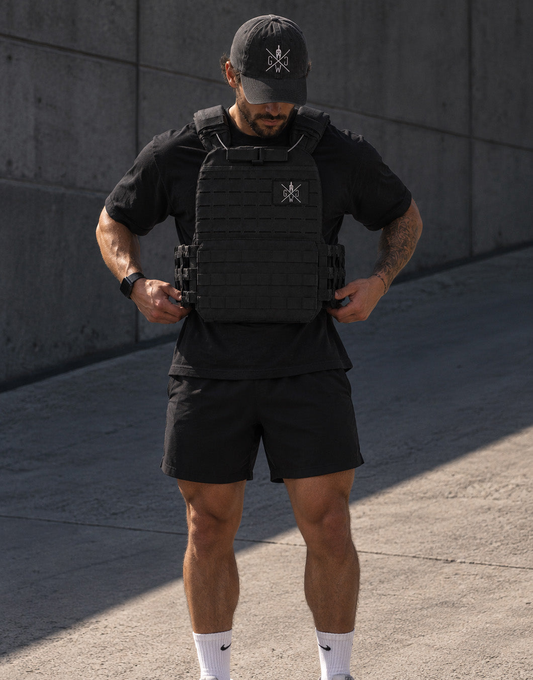 Athlete wearing the black Gym Generation weight vest, front view with a patch on the chest – adjustable training vest for outdoor workouts