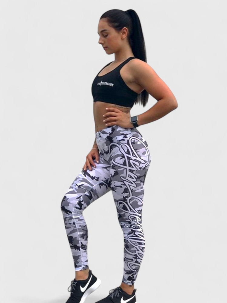 Athletisches Fitness-Model in grauen Camouflage-Leggings und schwarzem Sport-BH, kombiniert mit Sneakers, präsentiert einen sportlichen und modernen Look.