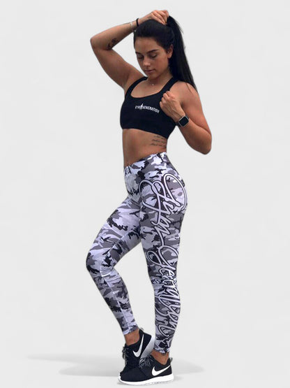 Fitness-Model in grauen Camouflage-Leggings mit Schriftzug und schwarzem Sport-BH, posiert mit athletischer Figur, ideal für Fitness, Workout und sportliche Freizeitmode.