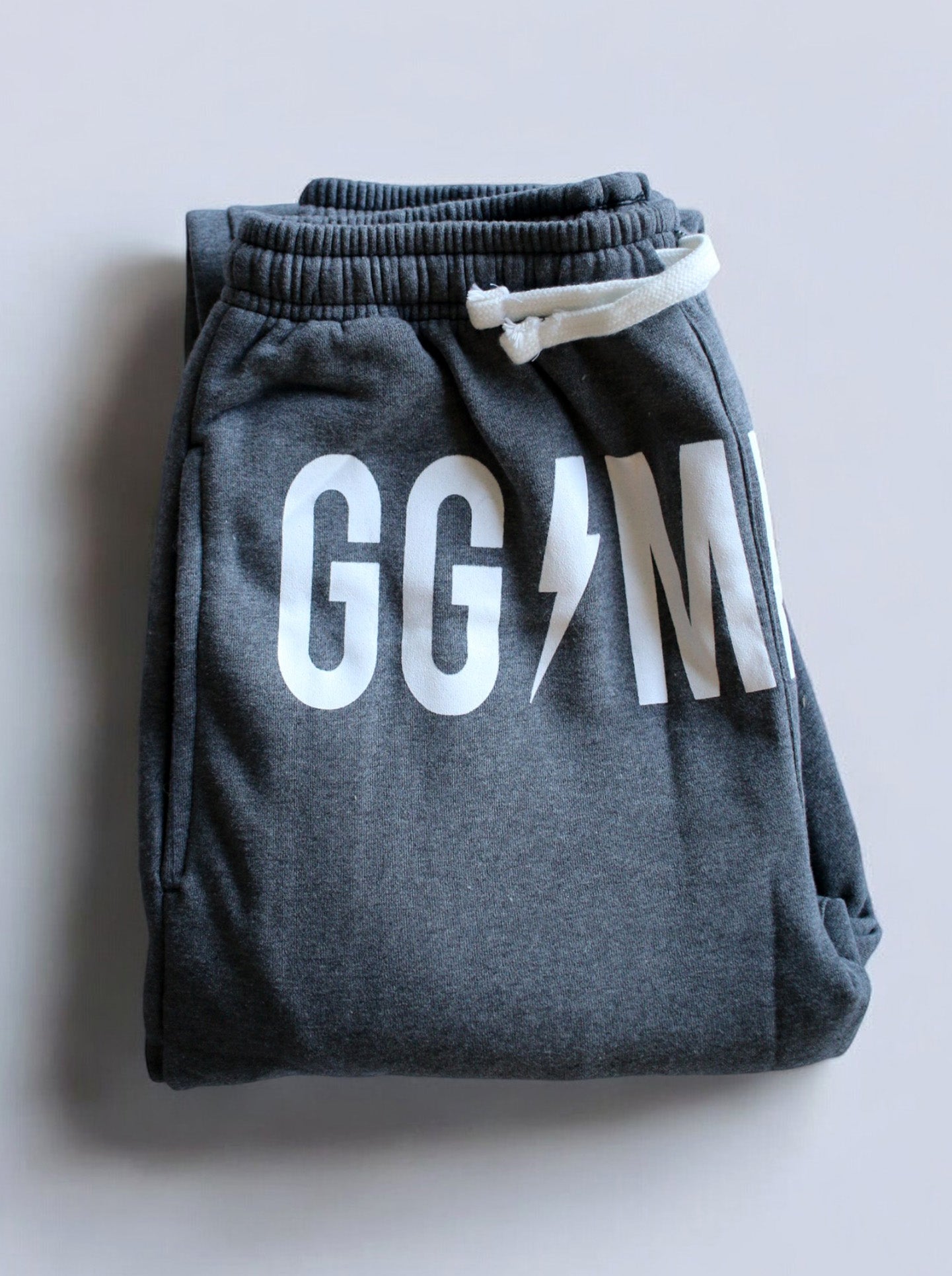 Comfortable grey gym pants with a stylish white logo print.
