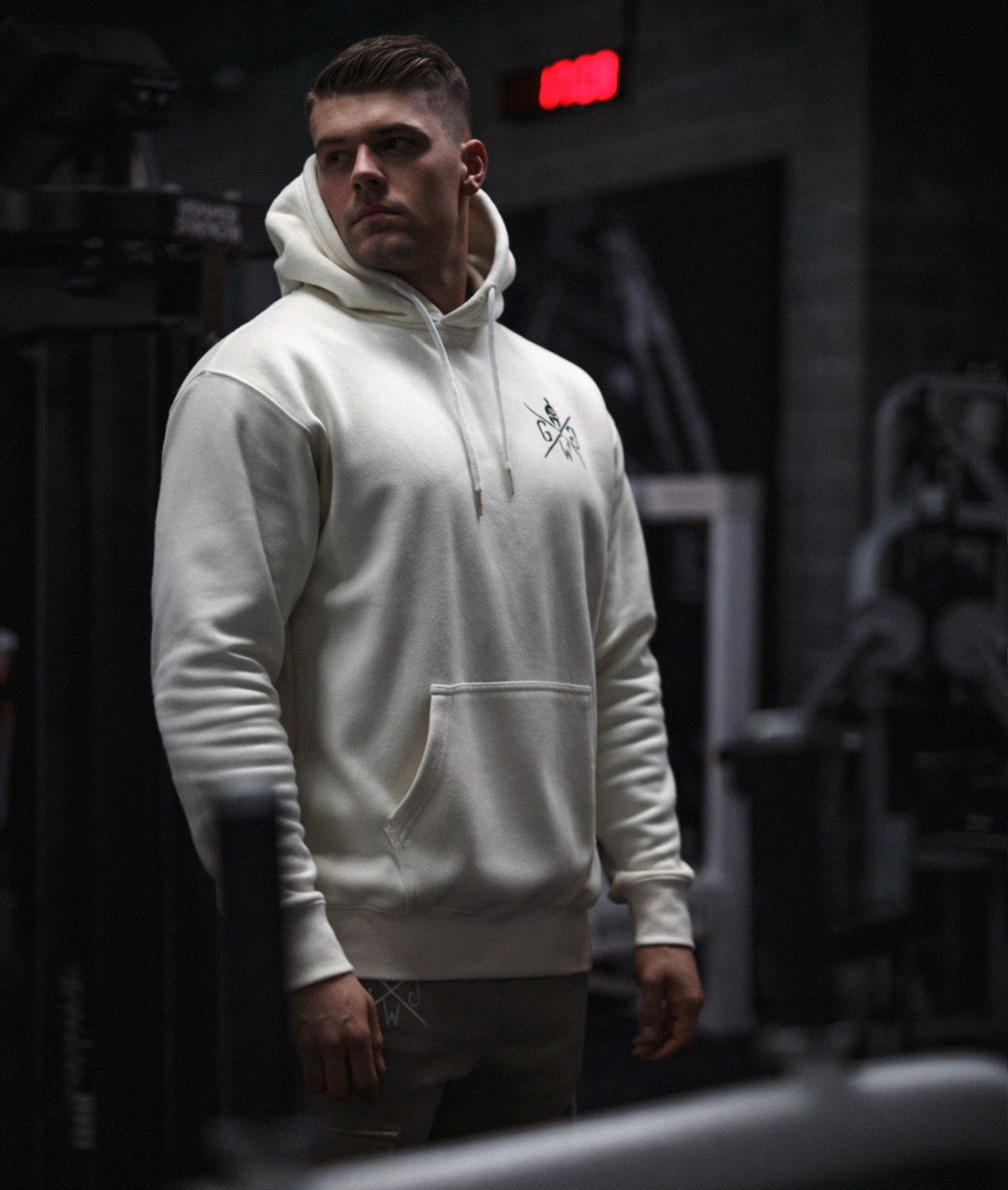 Athlet im Fitnessstudio trägt Off-White Gym Generation Herren Gym Hoodie mit Brustlogo, schräge Frontansicht