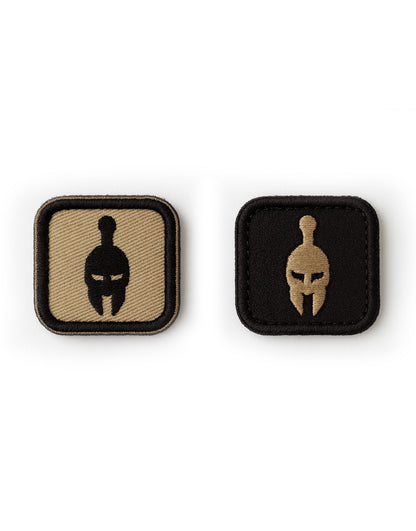 Zwei Spartaner Patches nebeneinander, freigestellt auf hellem Hintergrund, Klettverschluss-Rückseite und minimalistisches Warrior-Helmet-Design, perfektes Zubehör für Gym Generation Tactical Gear.