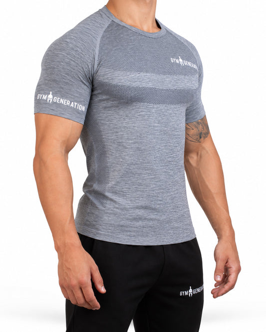 Gray men's seamless sport shirt from a three-quarter angle, close-fitting with raglan sleeves, honeycomb knit on chest and flank and lettering on the sleeve