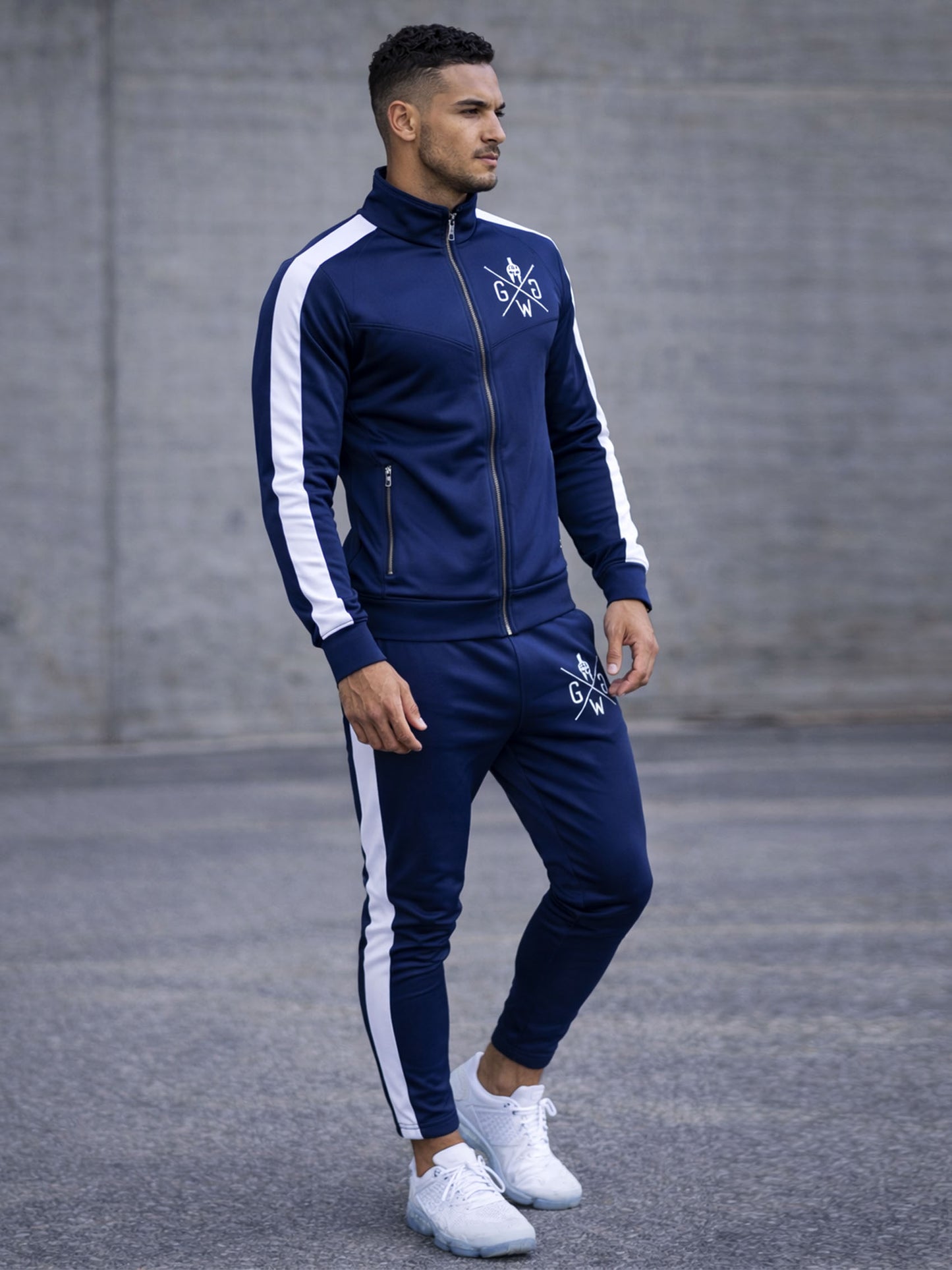 Gym Generation Herren Trainerhose in Navy Blau mit weißem Seitenstreifen als Urban Outfit getragen, sportlicher Trainingsanzug im Streetstyle