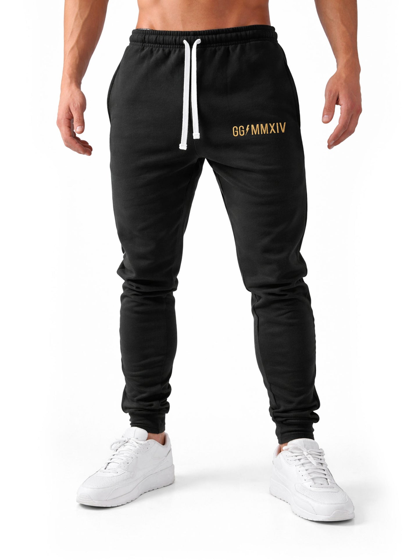 Frontale Studioaufnahme der Gym Generation Herren Trainerhose in Schwarz mit goldener GG MMXIV Stickerei und weißem Kordelzug, sportliche Trainingshose für Fitness und Krafttraining