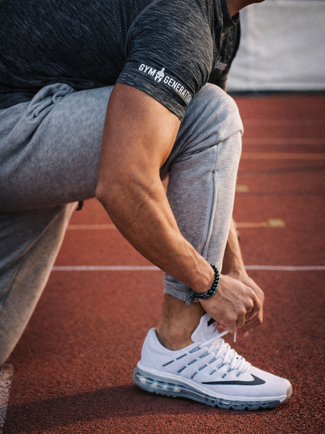 Gym Generation Herren Trainingshose grau getragen – dynamischer Lifestyle-Shot beim Sporttraining auf der Laufbahn