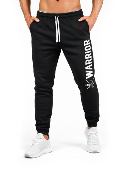 Frontansicht der schwarzen Gym Generation Herren Trainingshose mit Warrior Schriftzug, schlanker Passform und elastischem Bund für Fitness und Workout