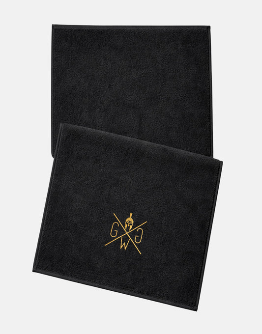 Schwarzes Fitness-Handtuch von Gym Generation mit goldenem Logo, Studio-Flatlay auf weissem Hintergrund.