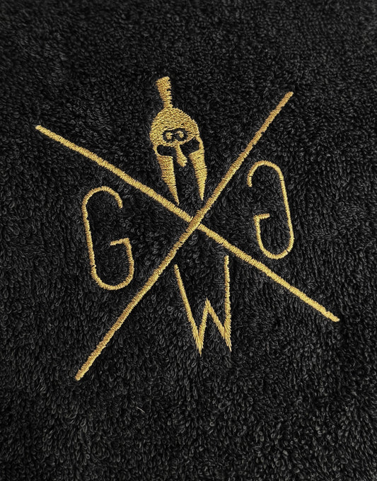 Nahaufnahme Sporthandtuch Schwarz mit goldenem Logo – edle Stickerei auf Baumwollstoff, Gym Handtuch von Gym Generation.