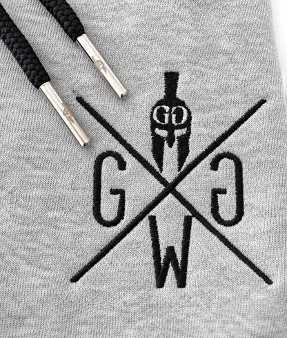 Schwarz gesticktes Gym Generation Logo auf grauem Hoodie Stoff mit schwarzen Kordeln und silbernen Metall-Caps, Premium Close-up Produktbild auf weissem Hintergrund