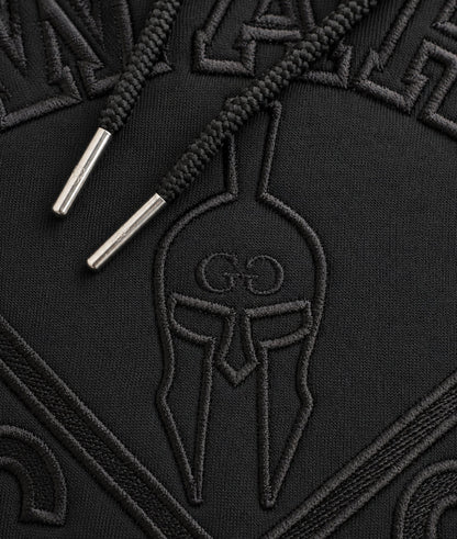 Detailaufnahme der schwarzen Gym-Warriors-Stickerei und des Kordelzugs mit silbernen Metallkappen