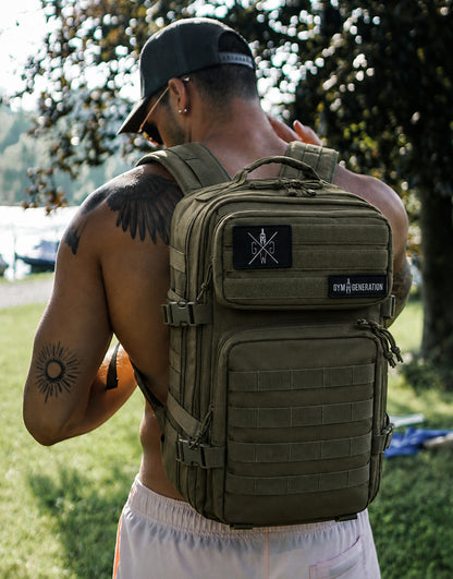 Gym Generation Fitness Rucksack Adventurer in Olive, getragen von Athlet Outdoor mit MOLLE-System, Patches und robustem Backpack-Design