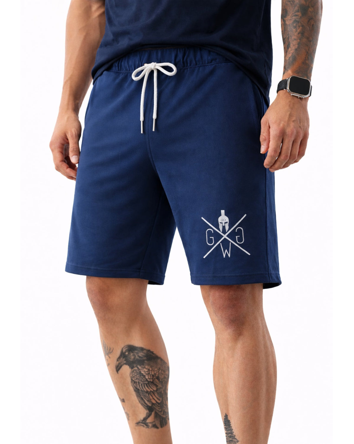 Herren Gym Shorts in Navy von Gym Generation am tätowierten Model – sportliche Passform mit weißem Kordelzug und markantem Beinlogo