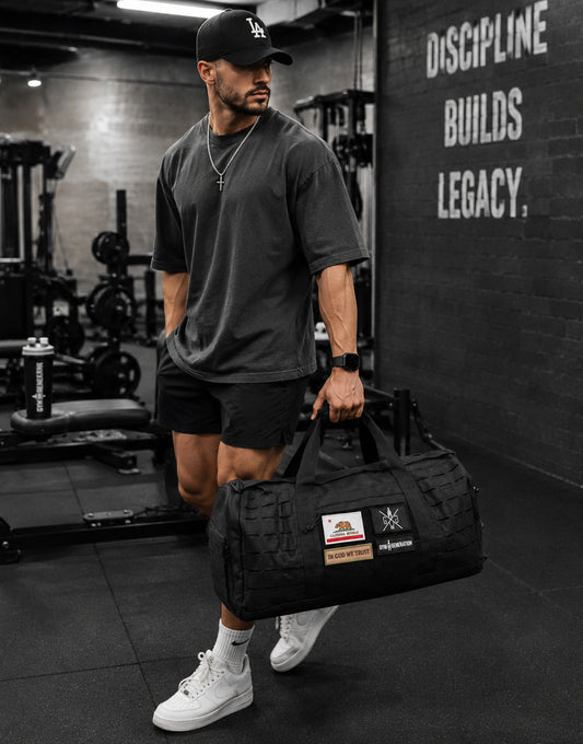 Gym Generation Gym Sporttasche Maverick in Schwarz, getragen von Athlet im Fitnessstudio mit Patches, Laser-Cut-MOLLE und robustem Trainingsdesign