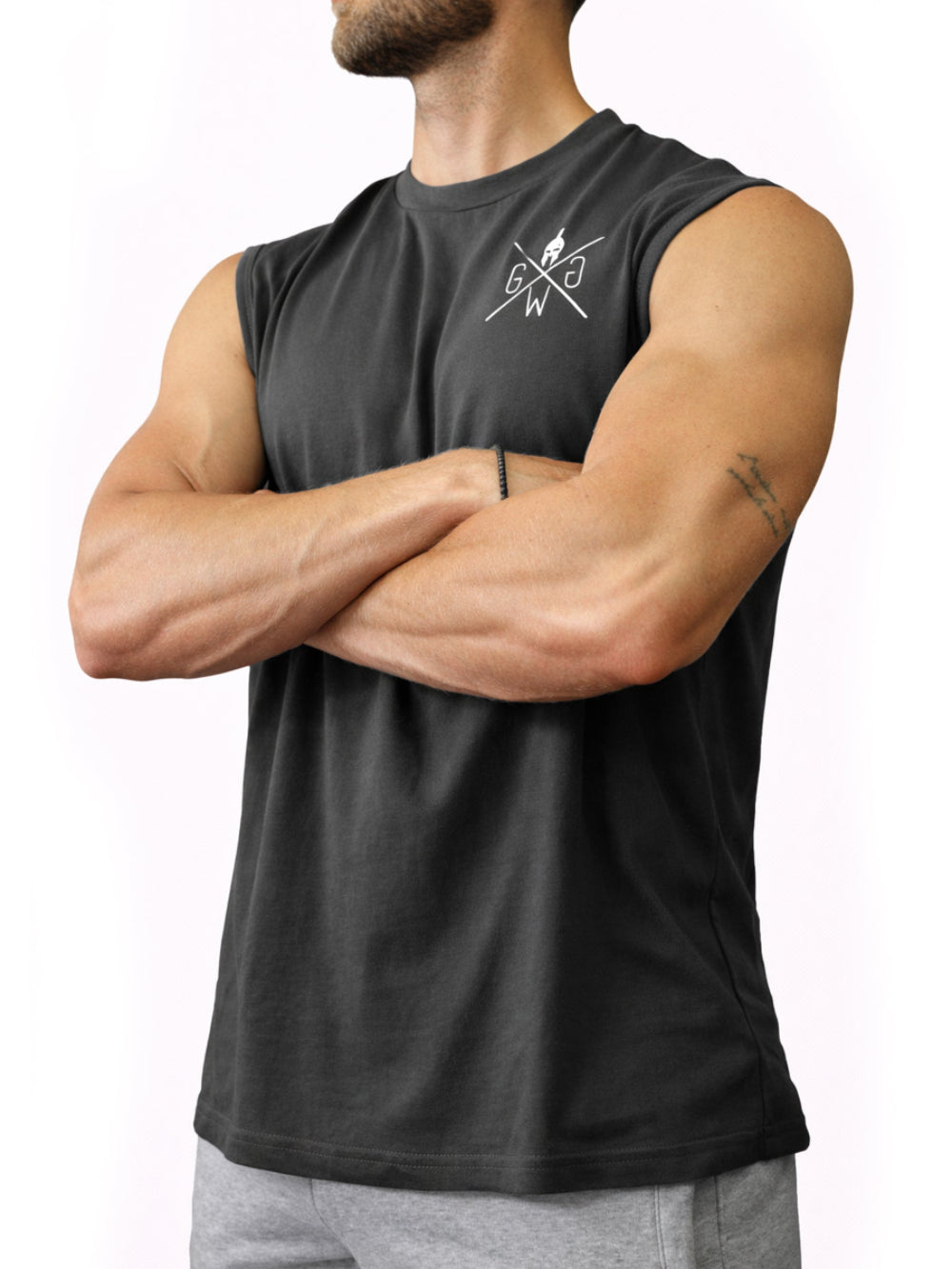 Dunkelgraues Herren Fitness Tank Top mit Brustlogo von Gym Generation am Model mit verschränkten Armen