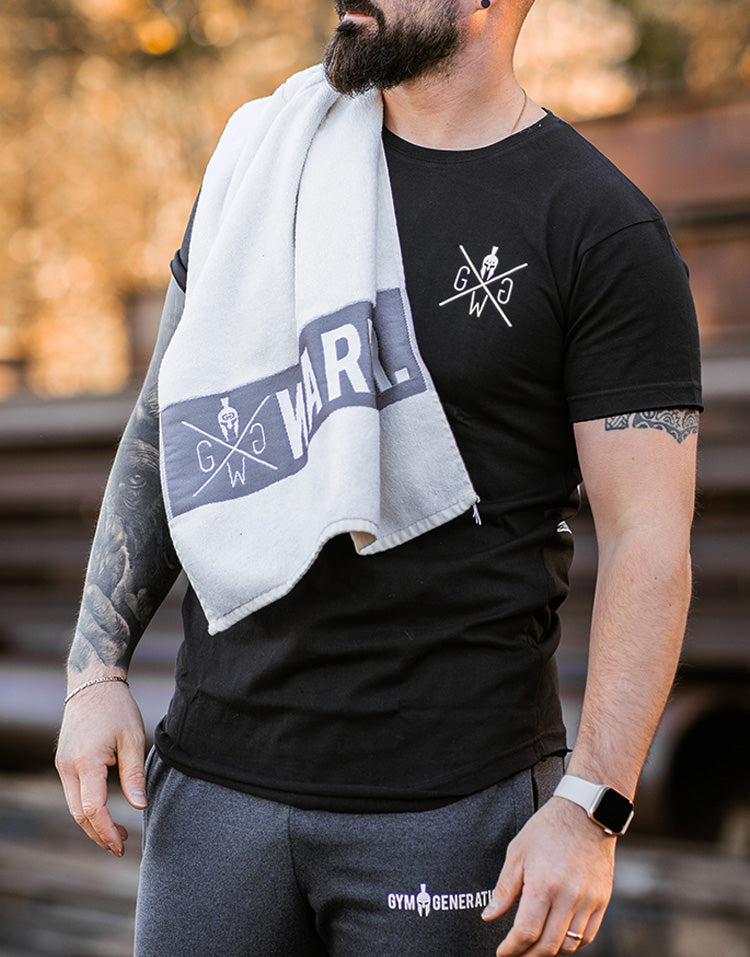 Weisses Gym Towel von Gym Generation mit Logo, über der Schulter eines Sportlers getragen.