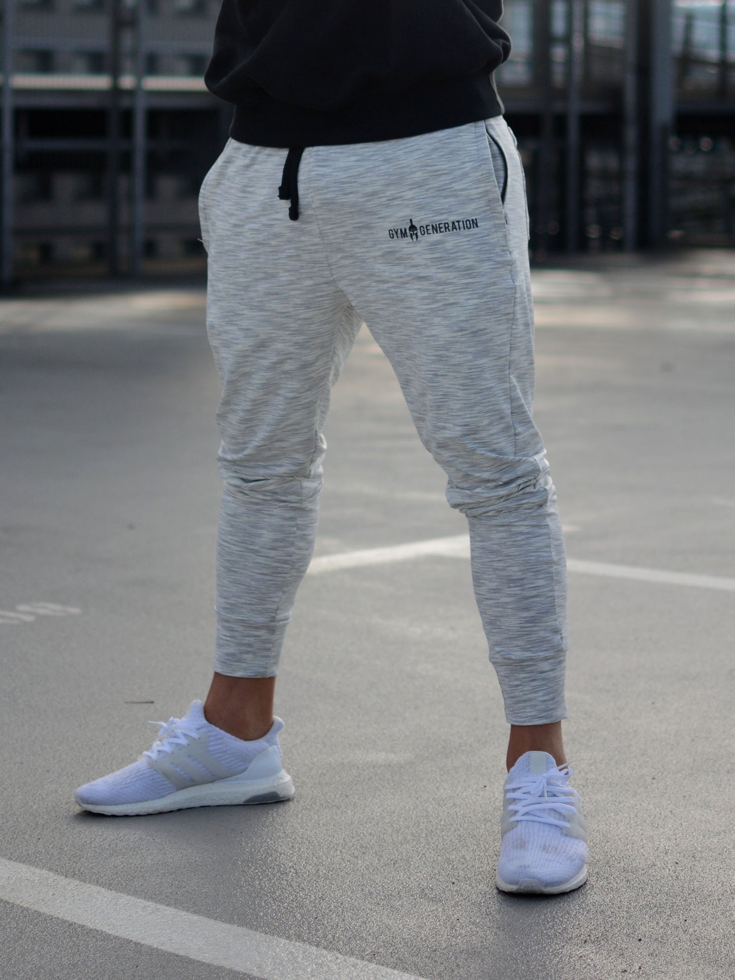 Stylische Sporthose von Gym Generation in trendigem Off White, getragen von einem sportlichen Mann mit Sneakers.