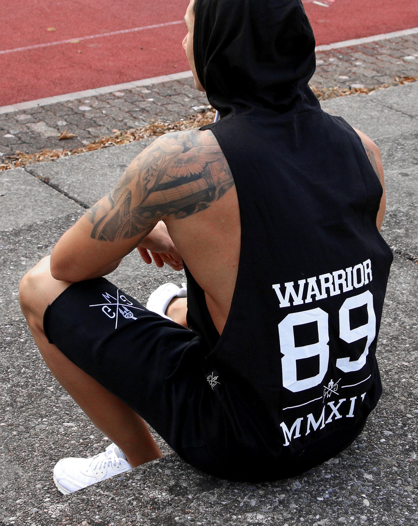 Schwarze Herren Sporthosen von Gym Generation, getragen von einem sportlichen Mann auf einem Sportplatz, perfekt für Komfort und Stil beim Training.