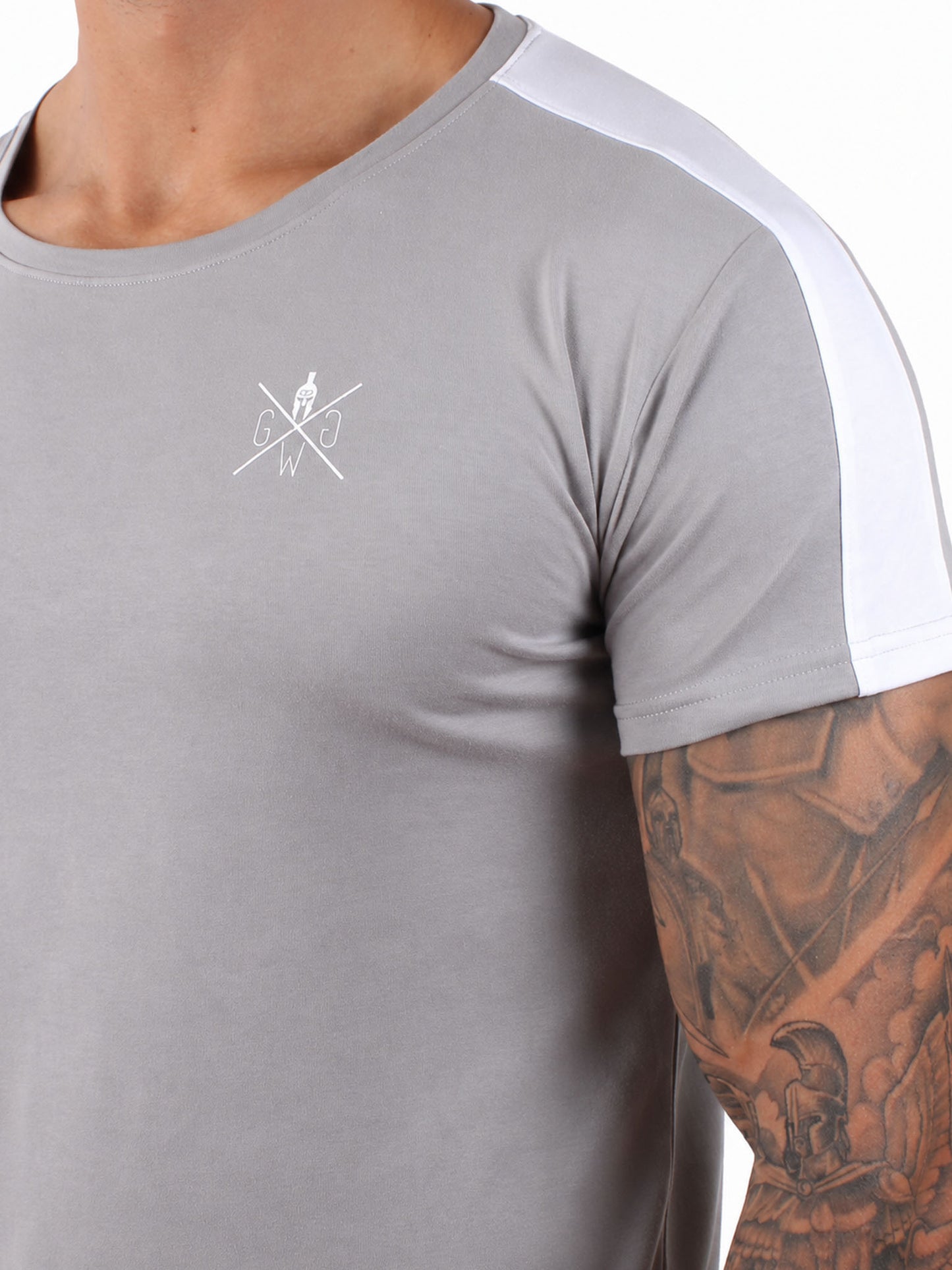 Detailaufnahme graues Fitness Shirt Herren mit weissem Gym Generation Brustlogo, glattem Stoff und weissem Schulterstreifen
